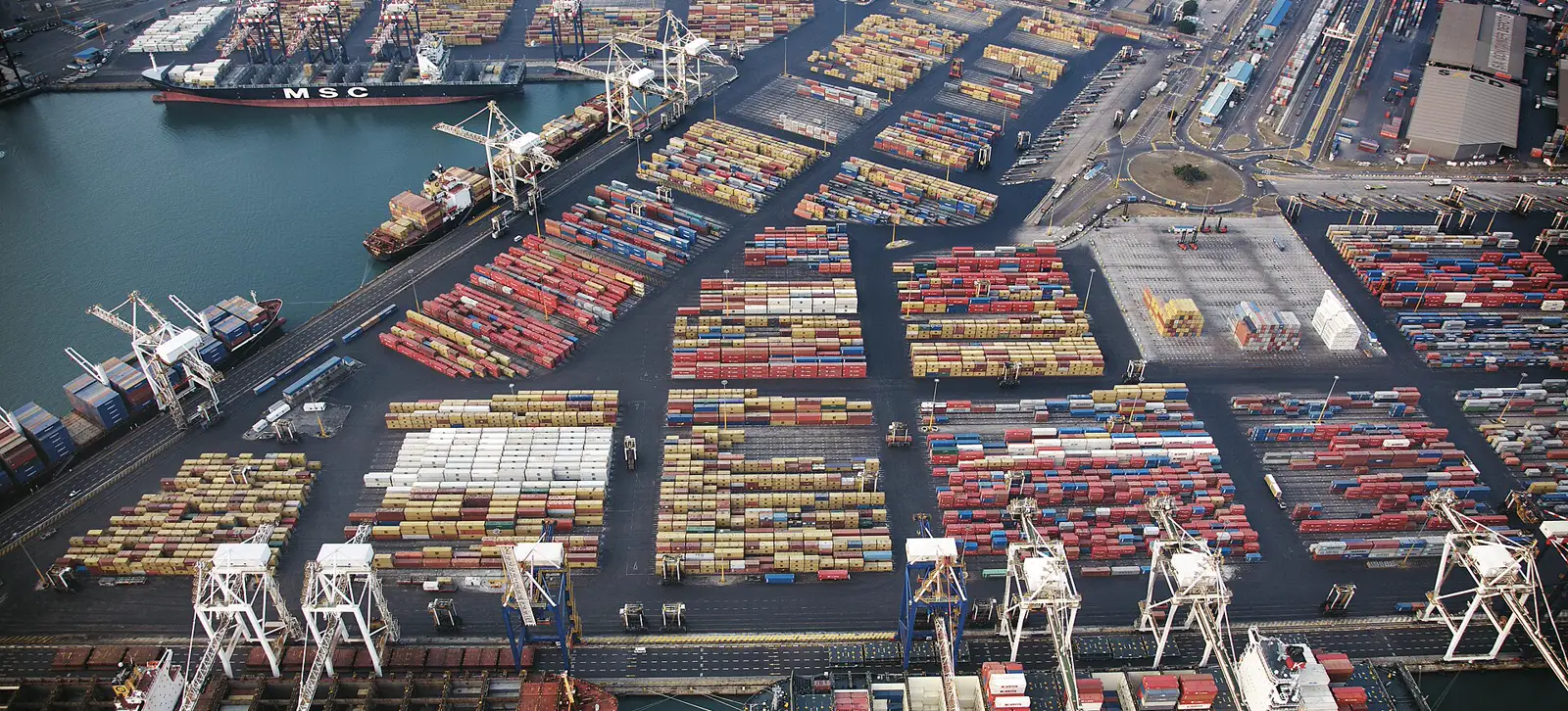 Aerial view of the container terminal at the Port of Durban, stacked containers and gantry cranes along the quay.